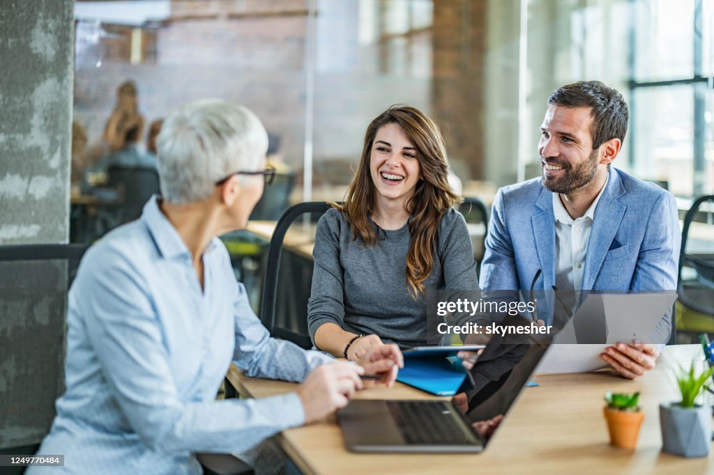 Happy couple communicating with their agent in the office.