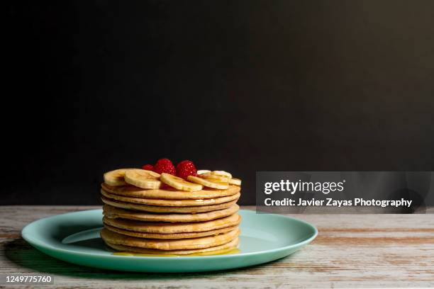 stack of pancakes with honey, bananas and raspberries - crêpe pancake photos et images de collection