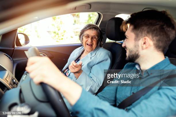 hogere vrouwen in een auto met caregiver - car young driver stockfoto's en -beelden
