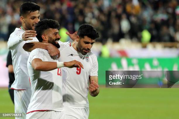 Iran's defender Ramin Rezaeian celebrates with teammates after scoring his team's second goal during the friendly football match between Iran and...