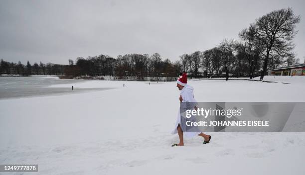 Member of Berlin's ice swimming club "Berliner Seehunde" makes his way to take a dip in the Orankesee lake during their traditional Christmas ice...