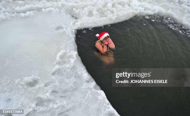 Member of Berlin's ice swimming club "Berliner Seehunde" takes a dip in the Orankesee lake during their traditional Christmas ice swimming session in...