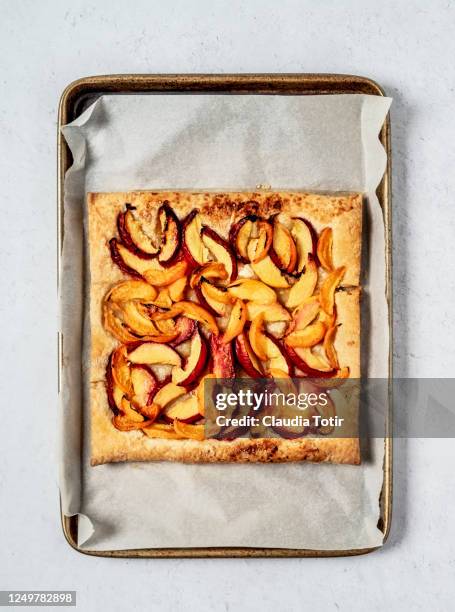 peach tart on a baking sheet on white background - baking sheet stock pictures, royalty-free photos & images