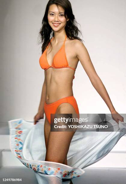 Japanese apparel maker Unichika's campaign model Emiko Koizumi displays a bikini swimsuit with a wrapped skirt during the 2000 swimwears collection...