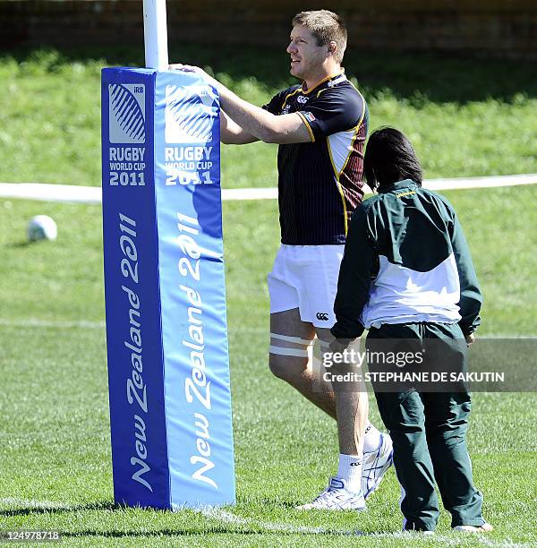 South African Springbok player Bakkies Botha stretches with physiotherapist Rene Naylor during a training session on September 14, 2011 in Wellington...