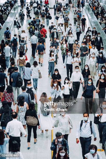 crowd of busy commuters with protective face mask walking through platforms at subway station during office peak hours in the city - covid-19 china stock pictures, royalty-free photos & images