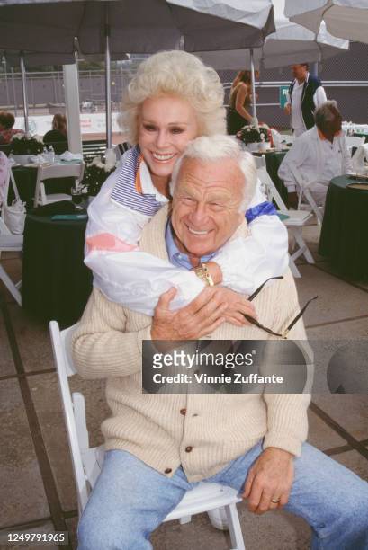 Hungarian-American actress Eva Gabor wraps her arms around American actor Eddie Albert , circa 1990.