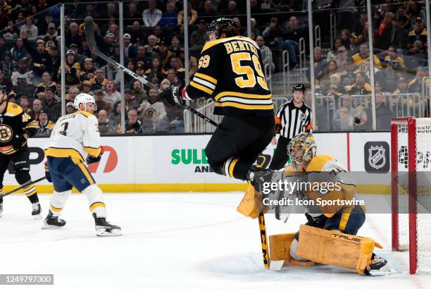 Boston Bruins right wing Tyler Bertuzzi leaps to avoid the shot on Nashville Predators goalie Juuse Saros during a game between the Boston Bruins and...