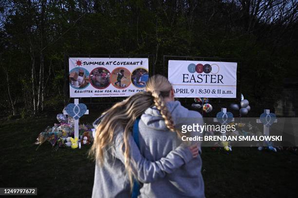 Peopel gather at a makeshift memorial for victims of a shooting at the Covenant School campus, in Nashville, Tennessee, March 28, 2023. - A heavily...