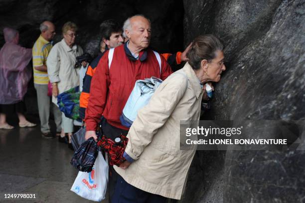 Pilgrims pray at the Grotto of Massbielle at the Sanctuary of Lourdes on September 11, 2008 ahead of the visit of Pope Benedict XVI who will...