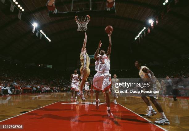 Juan Dixon, Guard for the University of Maryland Terrapins attempts the one handed lay up shot as Jon Babul, Forward for the Georgia Tech Yellow...