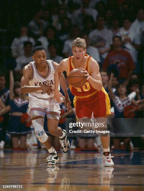 Fred Hoiberg, Guard for the Iowa State Cyclones dribbles the ball down court past Steve Woodberry of the University of Kansas Jayhawks during their...