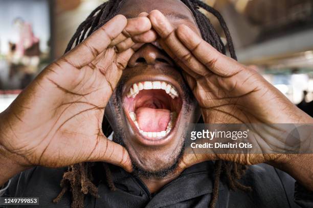 man shouting, closeup of his wide open mouth - wide stock-fotos und bilder