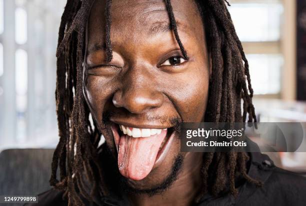 man winking with tongue out, closeup - colocar a língua para fora - fotografias e filmes do acervo
