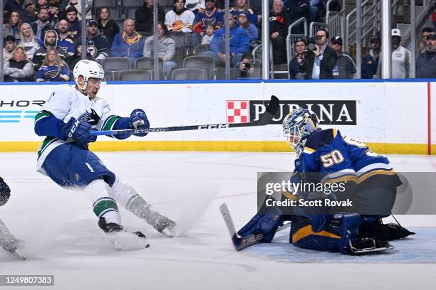 Jordan Binnington of the St. Louis Blues defends the net against Dakota Joshua of the Vancouver Canucks at the Enterprise Center on March 28, 2023 in...