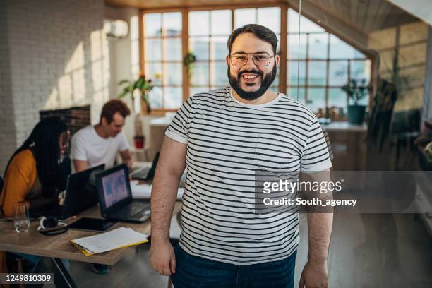 portrait of a man in small modern office - businesswear stock pictures, royalty-free photos & images