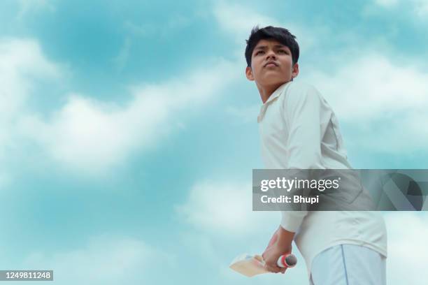ein junge in cricket-uniform und beim schlagen. - cricket game fun stock-fotos und bilder
