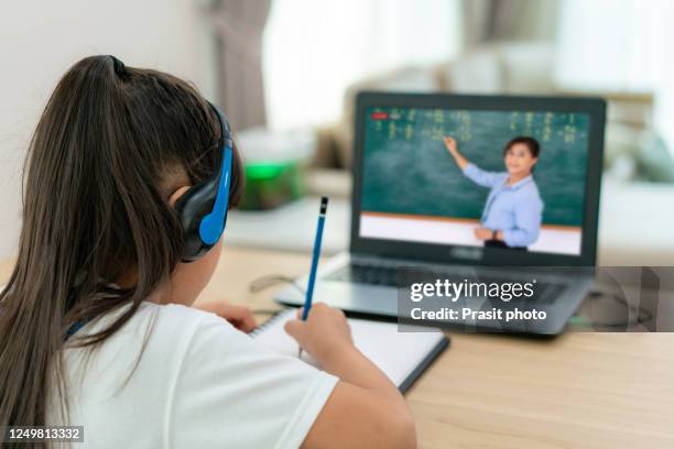 asian girl student video conference e-learning with teacher on computer in living room at home. homeschooling and distance learning ,online ,education and internet protect from covid-19 viruses. - online coach stock pictures, royalty-free photos & images