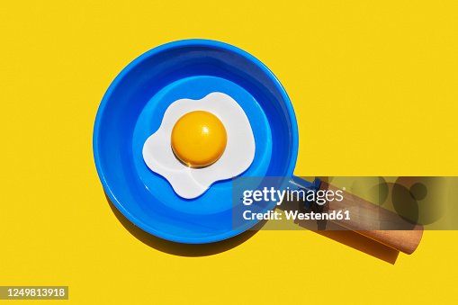 Illustration of fried egg on blue pan against yellow background Illustration of fried egg on blue pan against yellow background