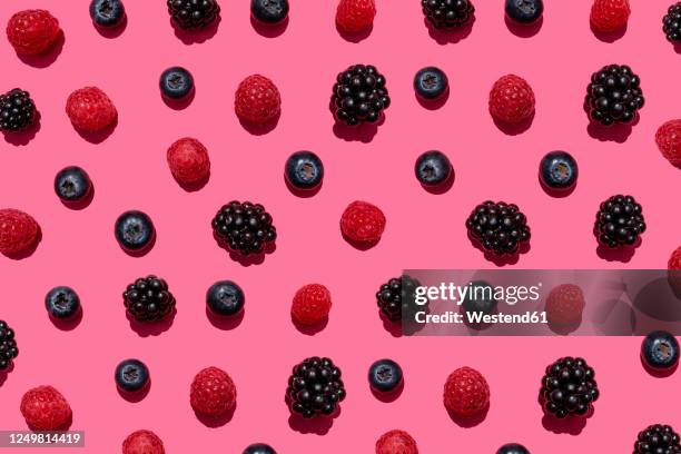 pattern of raspberries, blueberries and blackberries against pink background - berry fruit 個照片及圖片檔