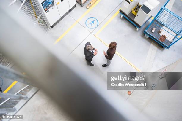 two businessmen meeting on factory shop floor - ansicht von oben stock-fotos und bilder