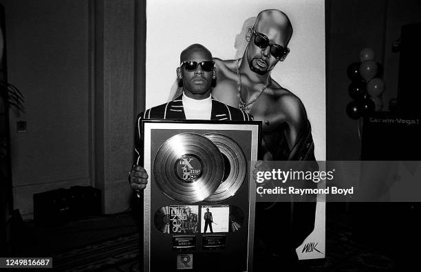 Singer R. Kelly poses for photos with his platinum plaque for his album '12 Play' during his '12 Play' Platinum Album party at Hotel Nikko in...