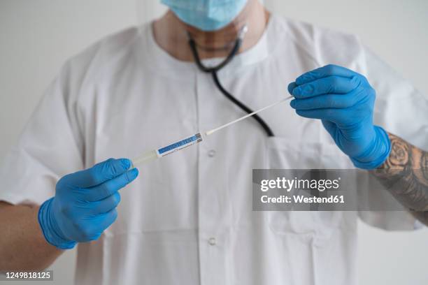 man in protective wear taking a covid-19 swab - cotton wool stock pictures, royalty-free photos & images