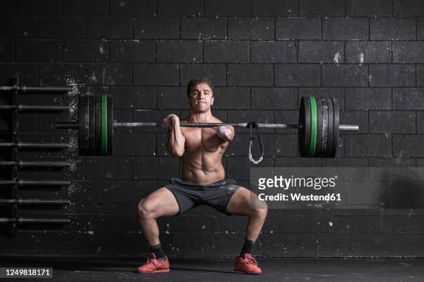 athlete with an amputated arm doing weight training - weight training foto e immagini stock