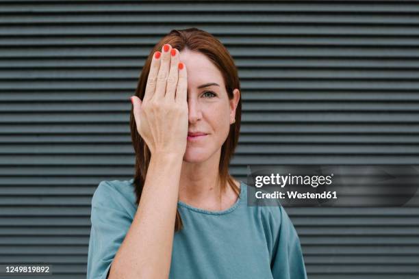 woman covering one eye with her hand - hand covering face stock pictures, royalty-free photos & images