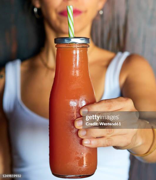 woman's hand holding glass bottle of fresh fruit juice, close-up - bottle condensation stock pictures, royalty-free photos & images