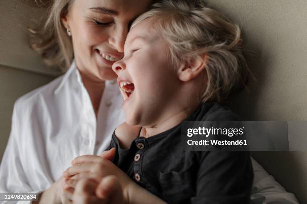 close-up of blond boy enjoying leisure time with mother at home - kids laughing close up bildbanksfoton och bilder