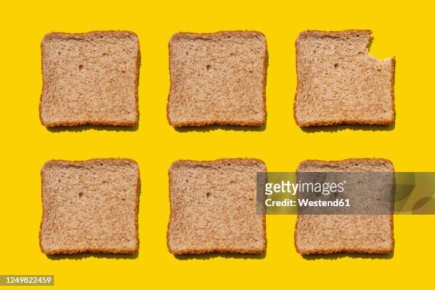 studio shot of six slices of wheat bread against yellow background - sliced bread bildbanksfoton och bilder