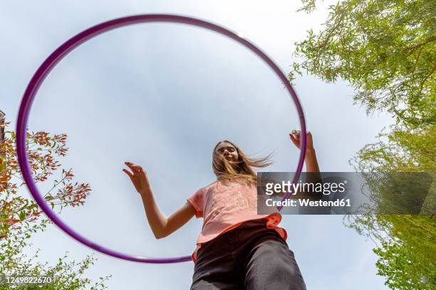 girl with hula hoop in garden - kid looking up to the sky imagens e fotografias de stock
