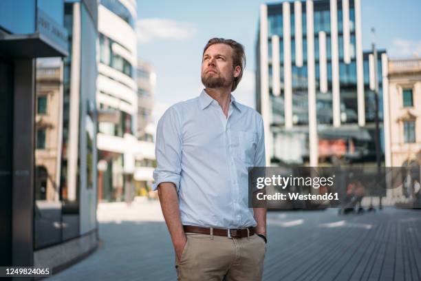 businessman in the city looking around - man looking up photos et images de collection