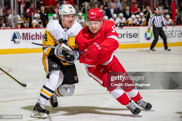 Jonatan Berggren of the Detroit Red Wings battles for position with Mikael Granlund of the Pittsburgh Penguins during the third period of an NHL game...