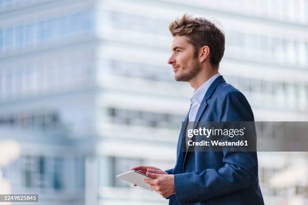 young businessman using tablet in the city - portrait waist up stock pictures, royalty-free photos & images