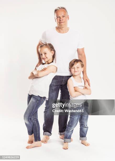 portrait of father with two children standing in front of white background - stolz freisteller stock-fotos und bilder