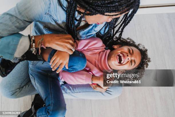 mother tickling her little daughter - kietelen stockfoto's en -beelden