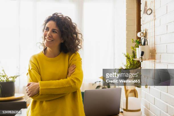 portrait of brunette woman having a break in home office - older woman with brown hair stockfoto's en -beelden
