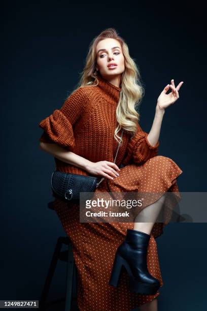 verticale de mode de femme élégante dans des vêtements bruns, fond foncé - sac à main blanc photos et images de collection