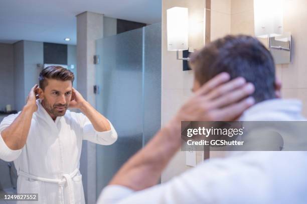 kaukasischer mann nach dusche styling seine haare im badezimmer - shampoo stock-fotos und bilder