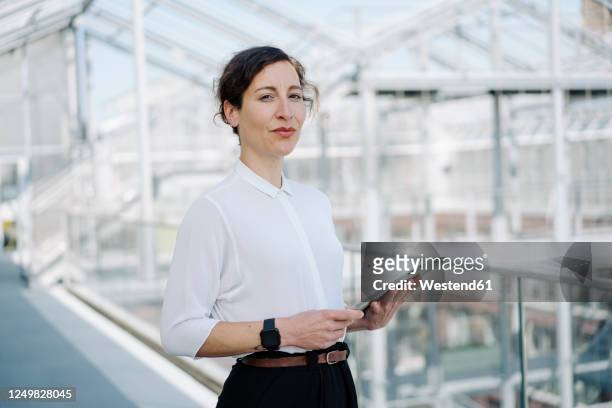 portrait of a confident businesswoman holding tablet - white blouse stock-fotos und bilder