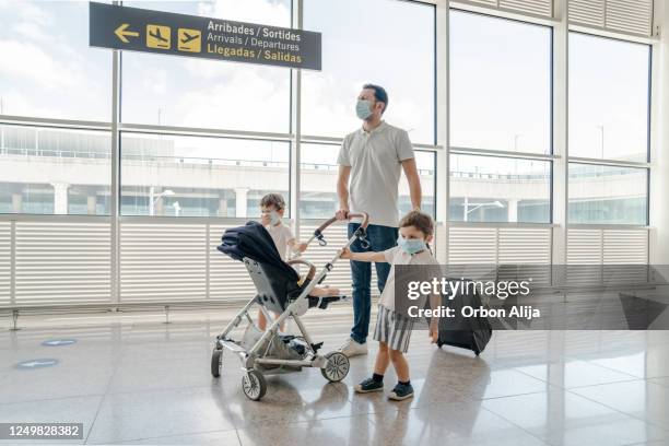 family travelling with face masks for covid-19 - baby stroller imagens e fotografias de stock