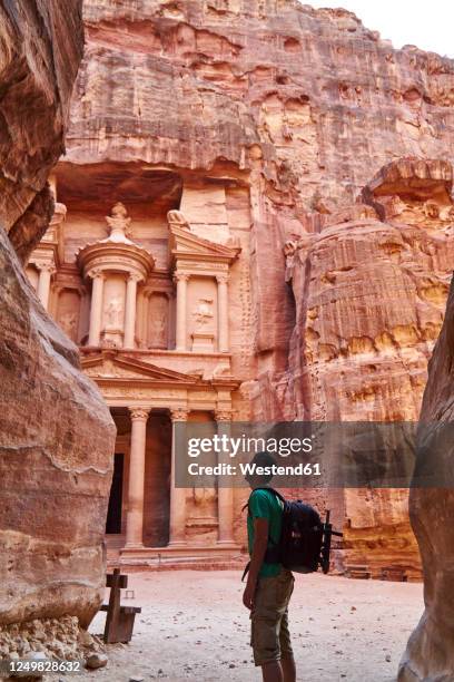 backpacker admiring the al-khazneh in petra, jordan - petra jordan stockfoto's en -beelden