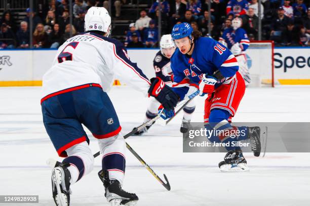 Artemi Panarin of the New York Rangers skates with the puck against Billy Sweezey of the Columbus Blue Jackets at Madison Square Garden on March 28,...
