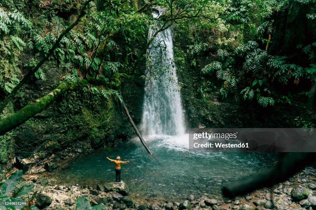 Rear view of man at a waterfall on Sao Miguel Island, Azores, Portugal
