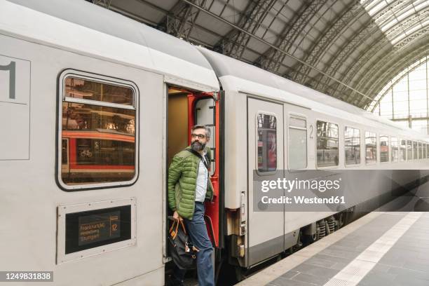 man getting off a train - disembarking stock pictures, royalty-free photos & images