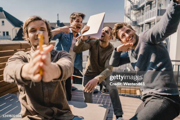 young entrepreurs having fun on a balcony, celebrating success - beginnings stock-fotos und bilder