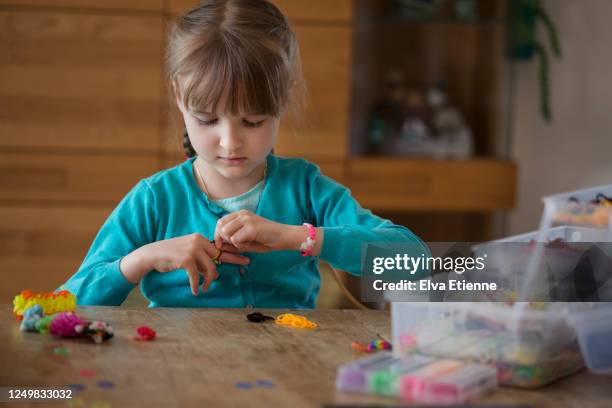 child making bracelets with multi coloured elastic bands - gummiband stock-fotos und bilder