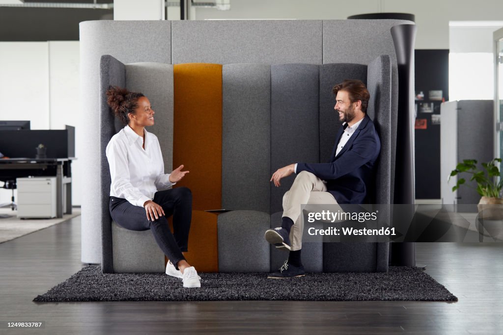 Colleagues keeping distance while talking together in office